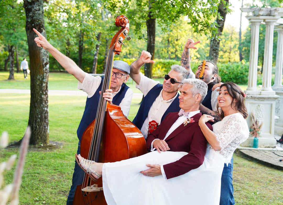 Des mariés avec un groupe de musiciens posent devant le photobooth dans un parc